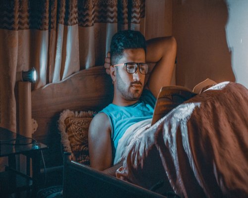 Person resting eyes while reading a book