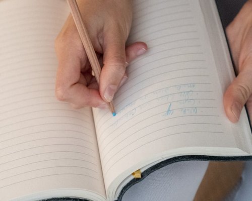 Close up of hands writing in a journal